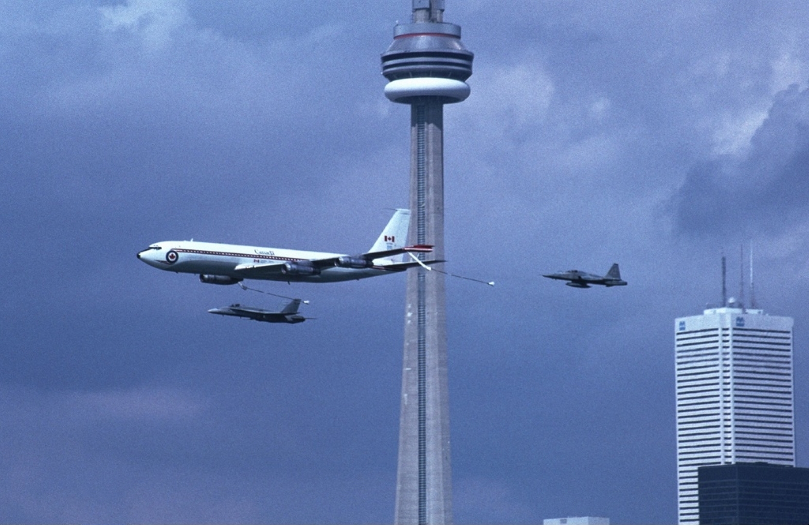 Canadian Armed Forces Boeing 707 (CC-137) leading Canadian Armed Forces' CF-5 Freedom Fighter (CF-116) & CF-18 Hornet (CF-188) past the CN Tower in Toronto, Ontario, Canada.